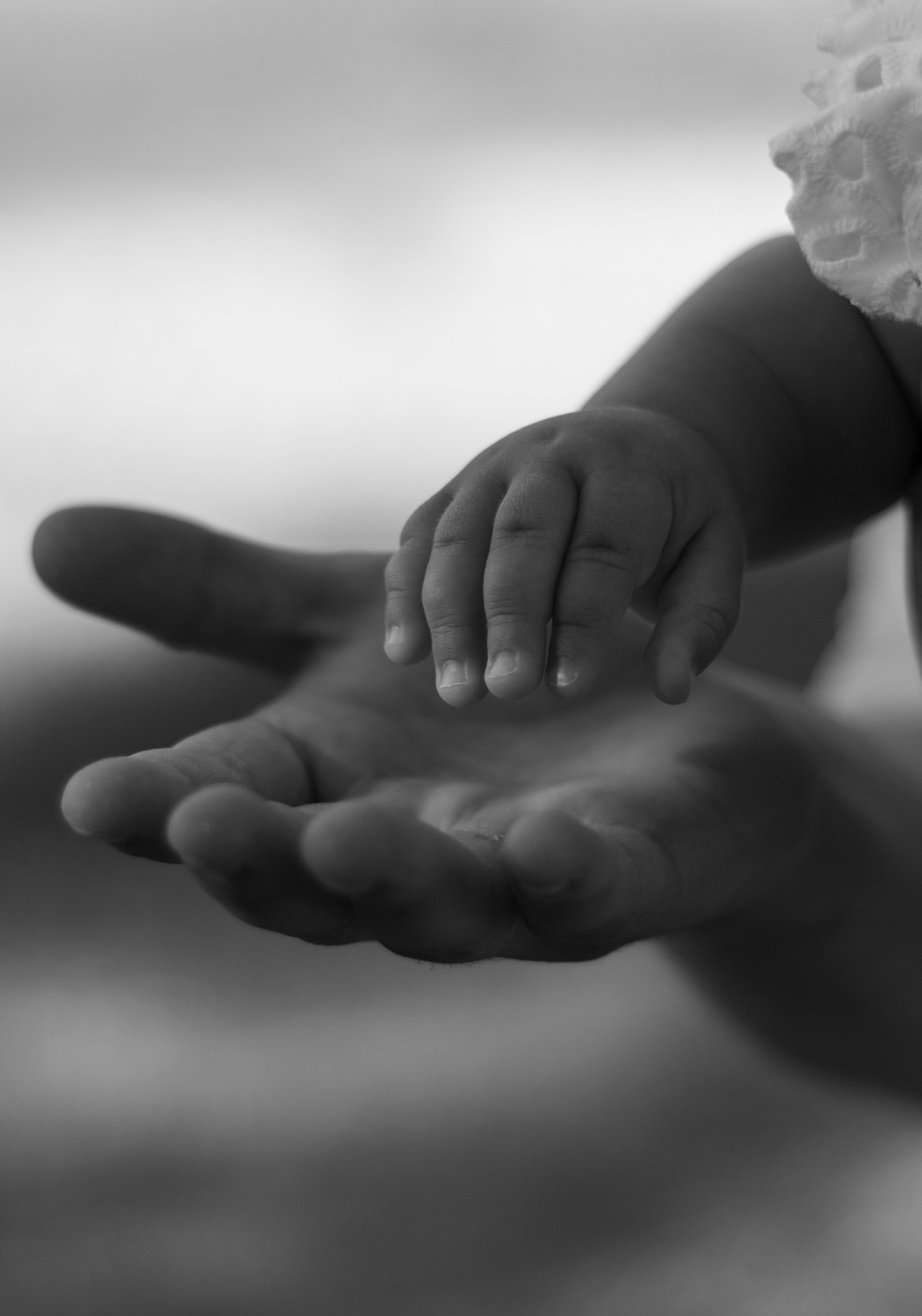 A child reaching toward an open hand